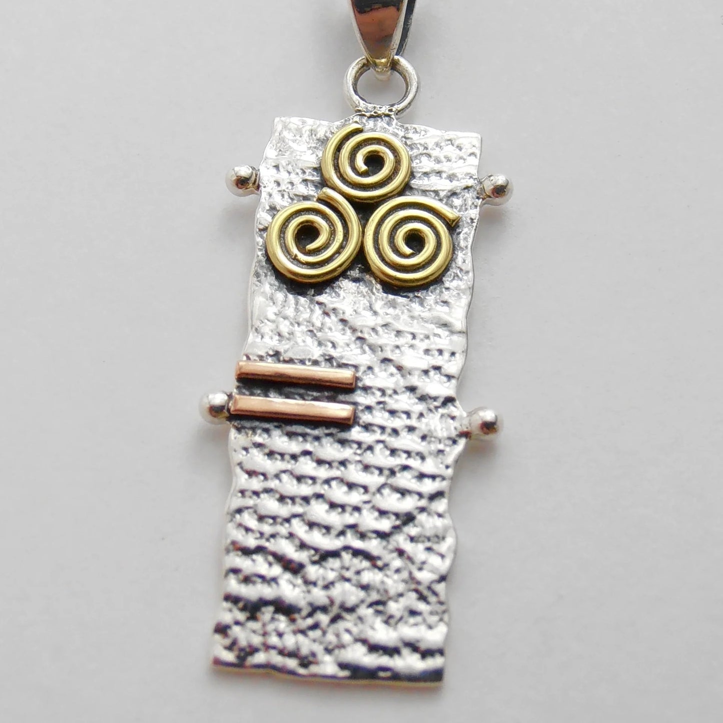 Ogham Pendant - textured lace vertical rectangle shape - sterling silvers - 3 brass spirals at top- 2short lines of copper below spirals