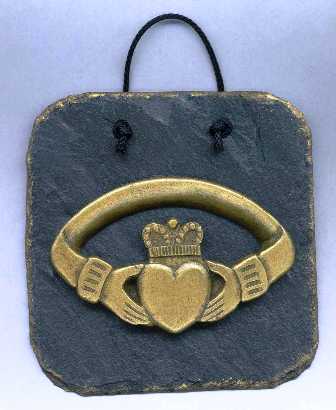 The Claddagh Ring Wall Plaque - The Claddagh motif is two hands holding a heart - The hands signify friendship, the heart love and the crown loyalty - The Caddagh design is coldcast in brass and then mounted onto a slate plaque 125mm x 125mm in size.