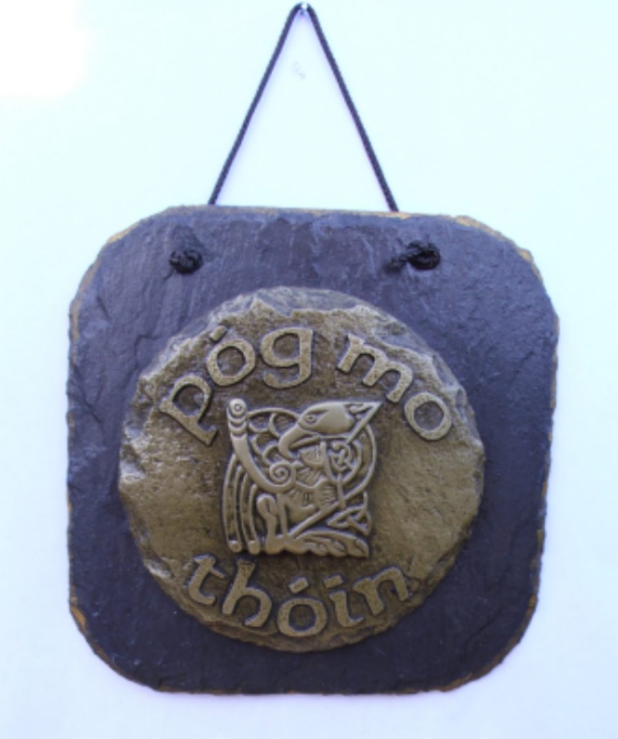 The Pog Mo Thoin Wall plaque -Pog Mo Thoin is the Irish phrase meaning" kiss my ass" - This design incorporates a bird design inspired by the Book of Kells and is coldcast in brass. The casting is then mounted onto a slate wall hanging plaque 125mm x 125mm in size -