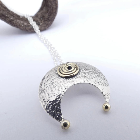 Lunula Pendant - crescent shape- two small balls of brass at each point of the crescent - brass spiral in the middle - crescent on its side - sterling silver